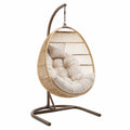Sedia a dondolo sospesa in rattan con cuscino beige, struttura in metallo