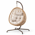 Sedia a dondolo sospesa in rattan sintetico e acciaio con cuscino beige